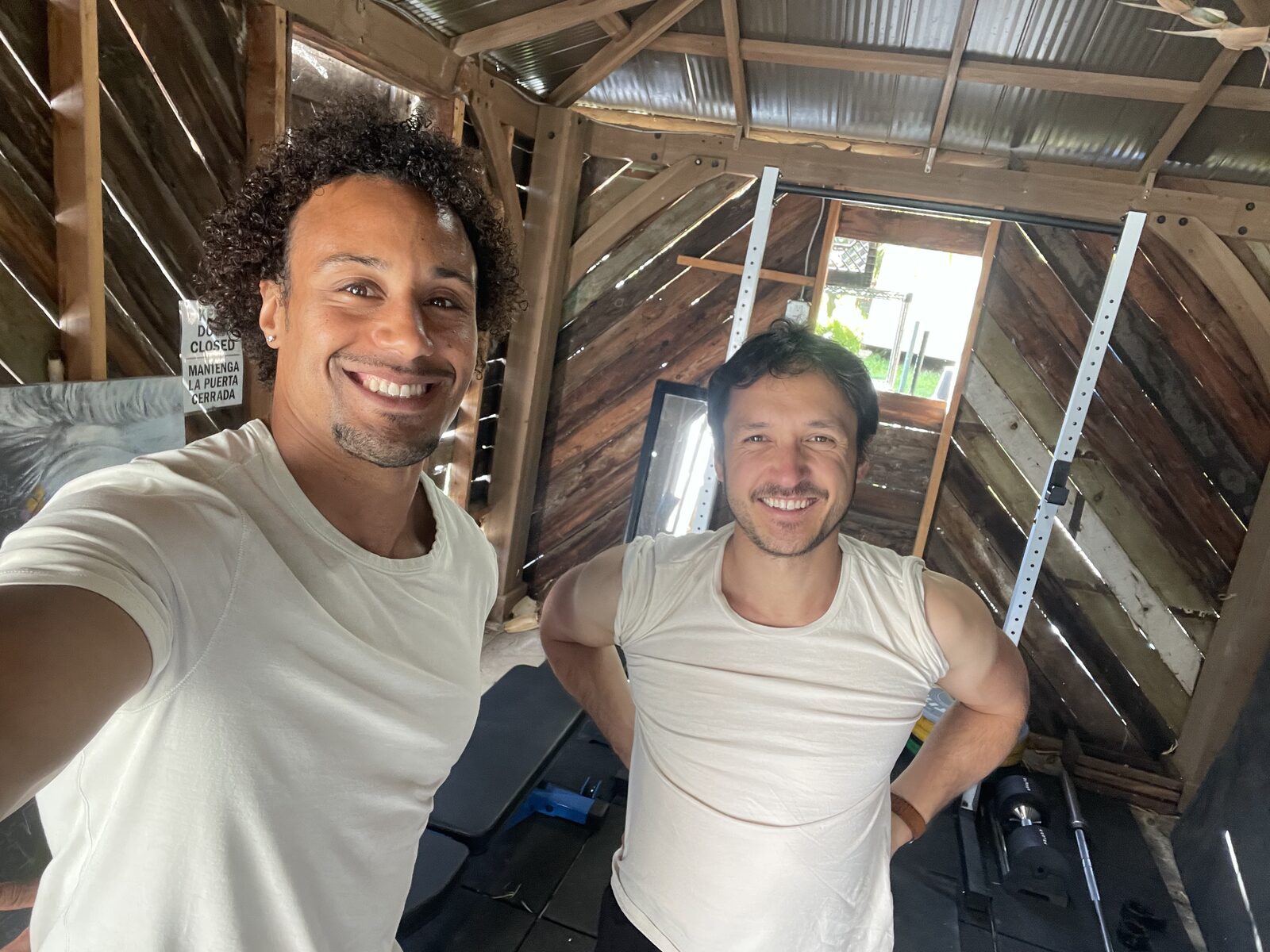 Two people smiling together inside the rustic wood training barn